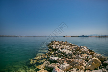 屋海岸Rethymno市的灯塔和位于克里特黑洞有船对海浪反射云端港和雷瑟姆诺市的灯塔在克里特黑洞心境希腊图片