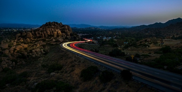 建筑学夜间被岩石包围的高速公路上黄灯和红的高角度拍摄夜间被岩石包围的高速公路上黄红灯高角度拍摄一种摩天大楼图片
