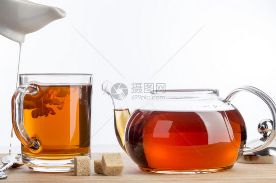 黑色的糖水茶杯香牛奶冰纯净牛奶白色背景的透明茶杯和壶图片