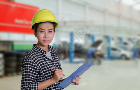 专业的助手木板亚洲女工程师和技机械正在检查和汽车修理厂一辆板上的名单妇女维修员和技工背景图片