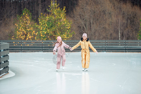 可爱的小女孩在冬天下雪户外溜冰场滑可爱的小女孩在冬天下雪户外溜冰场滑连指手套人们幸福图片