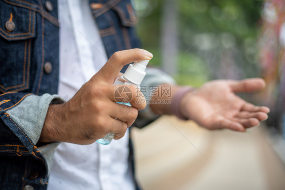 户外用酒精喷雾洗手的男性图片