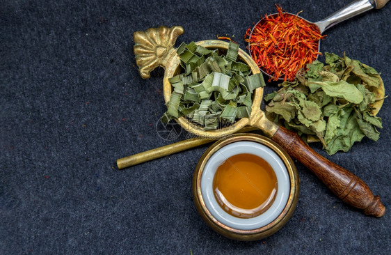 各种样的香气美味泰国草药茶与德里板丹草药印度沼泽跳蚤巴因和红花以及蜂蜜放在勺子上的蜂蜜饮料图片