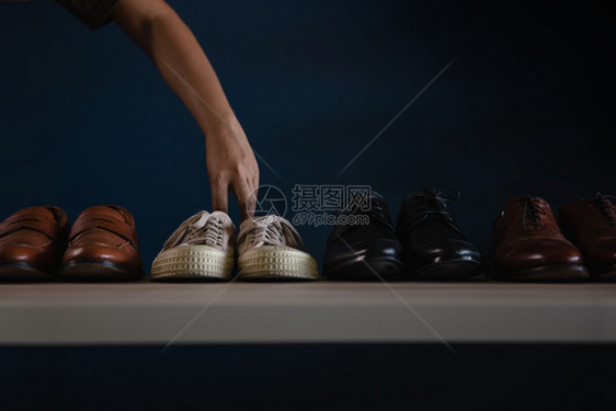 优雅男子穿鞋时的装男挑一件短鞋穿衣去不工作或平衡放松概念皮革时尚图片