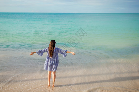 假期白色的沙滩热带海上快乐女孩的背影穿着绿礼服的年轻时装女郎在海滩上健康图片