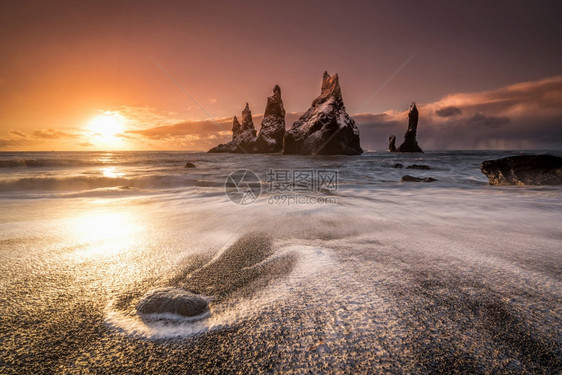 脚趾冰岛海滩黑沙和岩层在日落时以黑色沙子和岩石形成背景海岸美丽图片