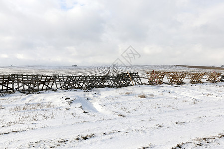 雪堆为冬季霜冻上午安装木栅栏的农耕田地野外Wooden围栏的雪在野外平坦的抽象图片