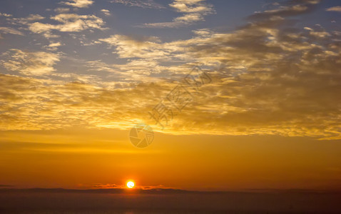 太阳球惊人的日出与美丽乌云在地平线上超过黄昏魔法图片