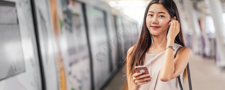 娱乐聪明的班纳网页或封面模板亚洲青年女乘客在地铁火车站日本钦那朝韩生活方式休闲和日常生活中使用智能移动电话并监听音乐以及新南朝鲜图片