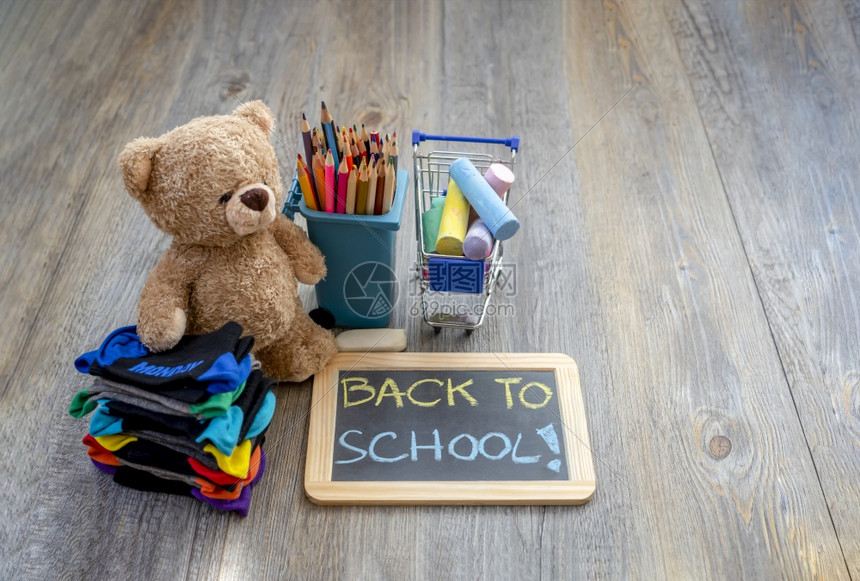 配件回到学校概念的TopSeaTeddy熊站在木地板上旁边有一堆儿童袜子纸板彩铅笔和购物纸桌中的彩粉笔黑板课堂图片