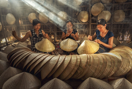 越南霍希明市ApThoiPhuoc村老旧传统房屋中越南女工匠集团传统艺术家概念传统艺术帽外衣的越南女工匠集团手制作的木造图片