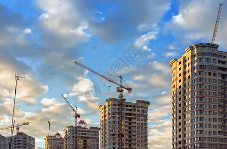 一种晴天俄罗斯莫科地区2017年6月建造新微小区筑起重机和新的住宅高楼建筑顶部以蓝色天空为敌建筑物图片