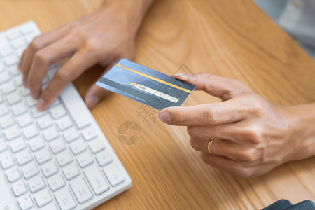 支付信用卡和进入安全码的男子在互联网上用笔记本电脑在线购物概念付款或买货物的网上商店交易时使用信卡和进入安全代码的人制造金融保持图片