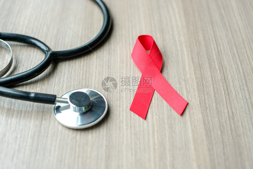 积极的艾滋病日与心脏癌症意识红丝带配有听诊器以支持人们生活和疾病保健概念红丝带用于支持人们的生活和疾病保健概念血液帕努瓦图片