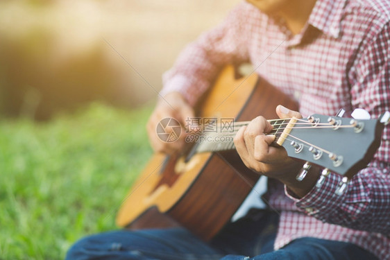 爱好黑色的男音乐家在公共园演奏声乐吉他MenMusicsDocultiveGutar场地图片