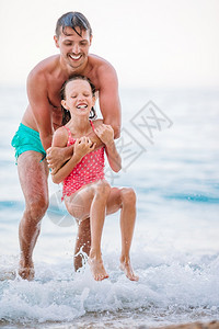 健康年幼父亲和女儿在海滩浅水中玩得开心暑假家庭度父亲和他的女儿享受海滩度假的乐趣滨请享用图片