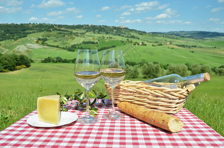 草地夏天桌上的白葡萄酒与意大利托斯卡纳景观面包图片