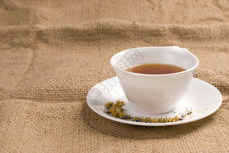文化人喝红茶在白陶瓷杯中背景薄饼图片