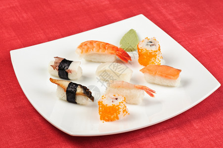 三文鱼美味的环境坐在白方盘子上的各种寿司片状图片