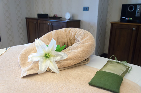 芳香疗法温泉室的毛巾鲜花和绿袋浪漫的浴室图片