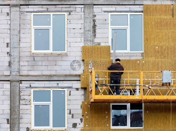 材料轮廓脚手架建筑者用摇篮和铝质图谱房屋节热概念建筑者在悬停的摇篮上站立用矿物绝缘来隔正在建造的房屋外墙建筑者将中的房屋表面隔绝图片