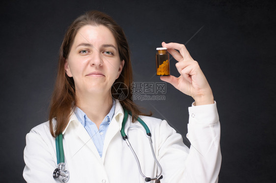 人们维他命补救持有一瓶药剂的女医生展示一瓶药的女医生图片