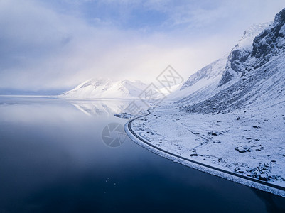 无人机冰地海岸线的空中景象沿海洋的道路和后面雪峰高山东弗湾冰岛欧洲等地天气旅游图片