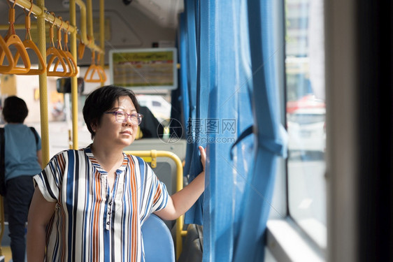 乘客穿梭亚洲40多位女在曼谷市Buses乘坐客车旅行这是曼谷市最重要的公共大众运输系统之一在曼谷亚裔女乘坐客车前往城市旅游中心图片