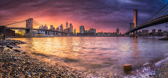 在布鲁克林桥的哈德逊河和海岸日落时曼哈顿桥上的纽约天线反射城市场景降低图片