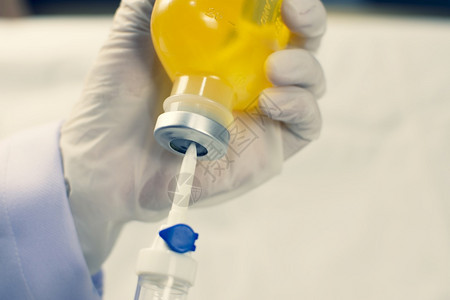 液体健康实验室NSS瓶Corona治疗概念Covid19医生将IV滴注射入正常的盐碱溶液图片