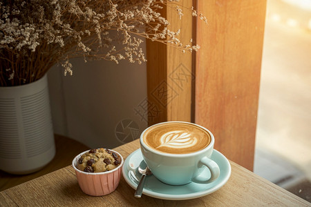 食物木制的店铺咖啡馆的早餐在商业工作概念期间在咖啡馆的店里吃早餐在商业工作构想中与茶杯的拿铁热咖啡和艺术牛奶泡沫加拿铁粉杯以及木图片