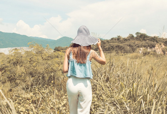 旅游放松夏天穿戴帽子旅行身处模糊的山峰和蓝天空背景穿着帽子旅行流浪癖图片