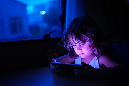 夜晚使用手机看视频的孩子图片