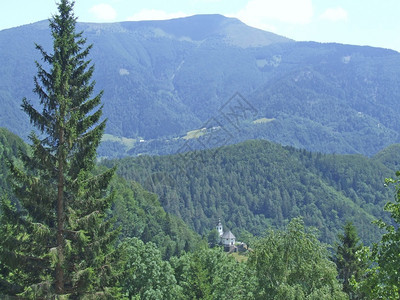 地平线山村景观教堂矗立在山间谷与村庄景观山与乡村教堂森林中的单一教堂山村景观教堂矗立在山间目的地游客图片