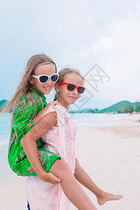 小女孩在热带海滩玩得开心在浅水边玩耍夏暑假的海滩上玩得愉快小姐妹们在热带海滩玩得很开心孩子在热带海滩玩得非常开心海岸线乐图片