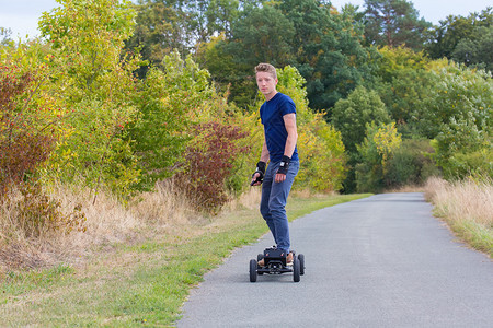 荷兰语方法欧洲的年轻人骑着电气的山坡在自然道路上图片