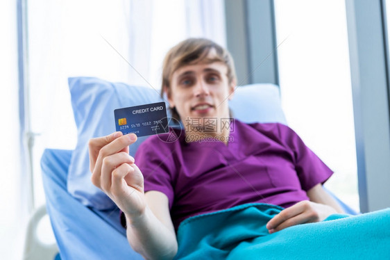 病床上手拿信用卡的男病人图片