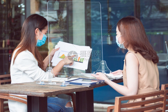 患病的沟通技术亚洲商业妇女在工作时佩戴面具和保持社会不动的亚洲商业妇女从事新的正常和商业概念图片