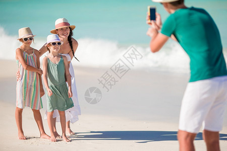 父亲在他们的海滩度假中拍照家庭四人自照片在他们的海滩节日上拍摄影师爱制造图片