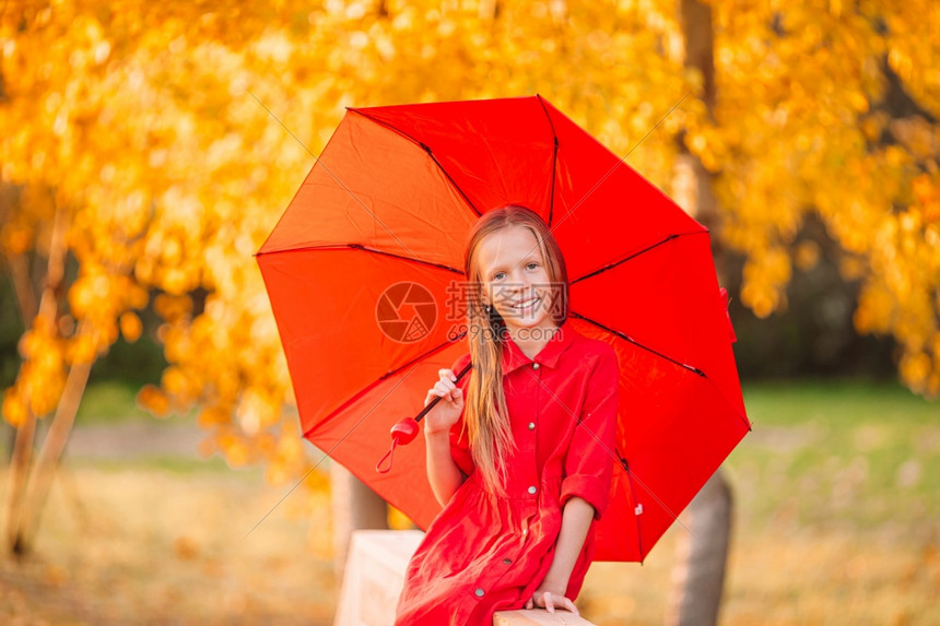 婴儿快乐可爱的小孩秋天带着红伞快乐的女孩笑在红伞下愉快面图片