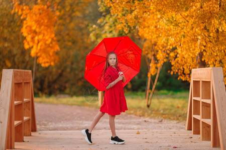 孩子防水的丰富多彩快乐可爱小孩秋天带着红伞快乐的女孩笑在红伞下图片