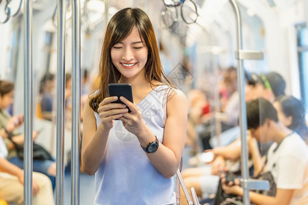 东亚洲青年女乘客在大城市japanesechinese朝韩生活方式和日常通勤和运输概念上旅行时通过地铁火车智能移动电话使用社交网图片