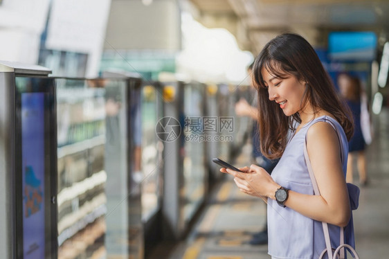 亚洲青年女乘客在大城市japanesechinese朝韩生活方式和日常通勤和运输概念上旅行时通过地铁火车智能移动电话使用社交网络图片