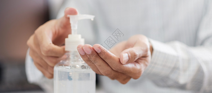 使用消毒液洗手的人特写背景图片