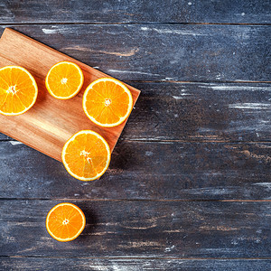 颜色团体有创意的黑暗风格平板最顶端是棕色木桌背景切割板上的新鲜橙子水果切片复制空间最小夏季鲜红柑橘成分用于博客或食谱书橘子图片