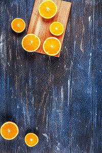 有创意的黑暗风格平板最顶端是棕色木桌背景切割板上的新鲜橙子水果切片复制空间最小夏季鲜红柑橘成分用于博客或食谱书有机的甜点平坦图片