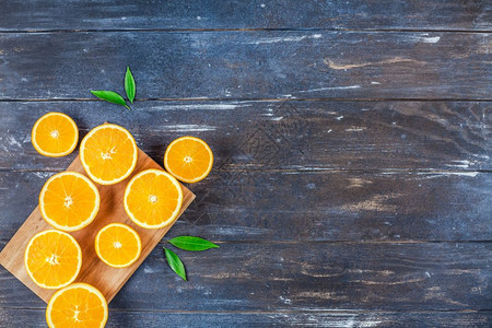 明亮的橘子有创意黑暗风格平板最顶端是棕色木桌背景切割板上的新鲜橙子水果切片复制空间最小夏季鲜红柑橘成分用于博客或食谱书颜色图片