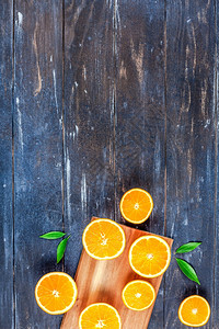有创意的黑暗风格平板最顶端是棕色木桌背景切割板上的新鲜橙子水果切片复制空间最小夏季鲜红柑橘成分用于博客或食谱书多汁的黑暗夏天图片