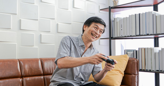 亚洲高龄男子使用平板和虚拟现实模器在客厅玩游戏并家里感到幸福的生活方式老年人家庭概念利用平板和虚拟现实模器屋房间专业知识图片
