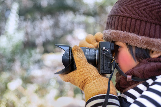 冬天眼睛一个穿着Woolhat的可爱小女孩肖像在天气下用数码摄影机拍照时脸色模糊而寒冷摄影概念看图片